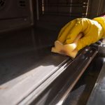 Technician deep cleaning a kitchen oven in Essex with non-toxic products
