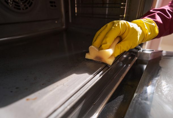 Technician deep cleaning a kitchen oven in Essex with non-toxic products