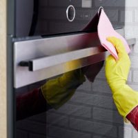 people-housework-housekeeping-concept-close-up-woman-hand-protective-glove-with-rag-cleaning-oven-home-kitchen_179369-29
